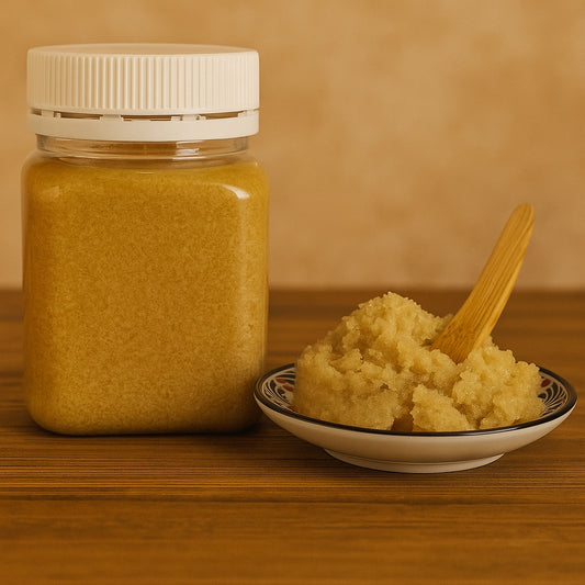 ceramic bowl with emulsified body scrub and wooden scoop and the jar with scrub