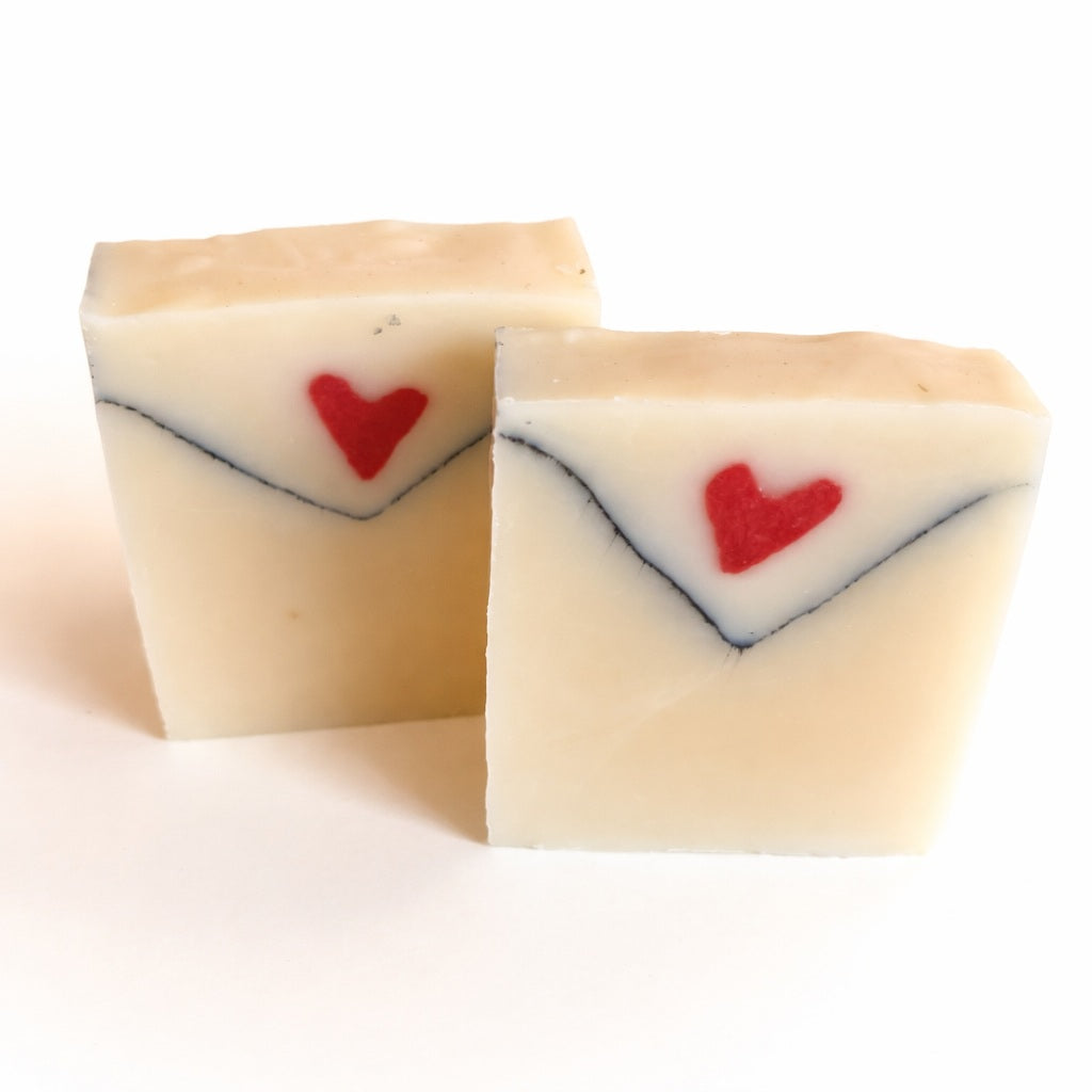 Love Letter handmade soap shaped like an envelope with a red heart, photographed on a clean white background