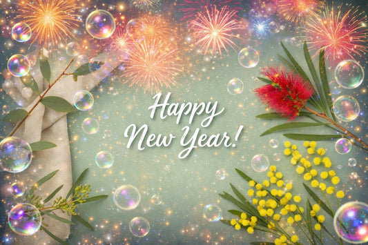 Festive New Year–themed flat lay with eucalyptus leaves, red bottlebrush flowers, yellow wattle, sparkling fireworks, and floating bubbles over a soft mint green background.