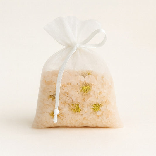 White sheer bag containing Himalayan pink salt and chamomile flowers, 