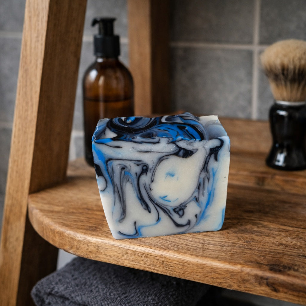 Handmade marbled soap with blue, black and cream swirls displayed on a wooden bathroom ladder shelf, country chic