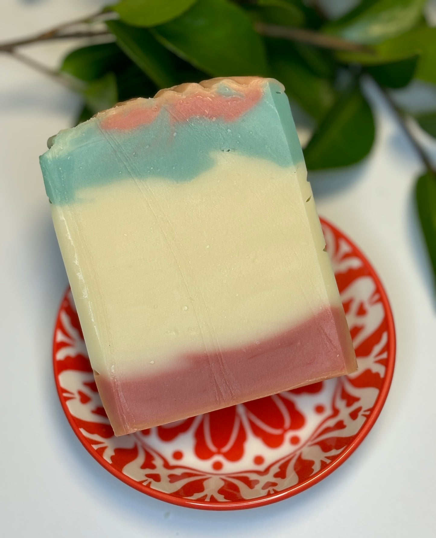 Handmade soap bar with Cedarwood and Mint, swirled with red, white, and green colours.