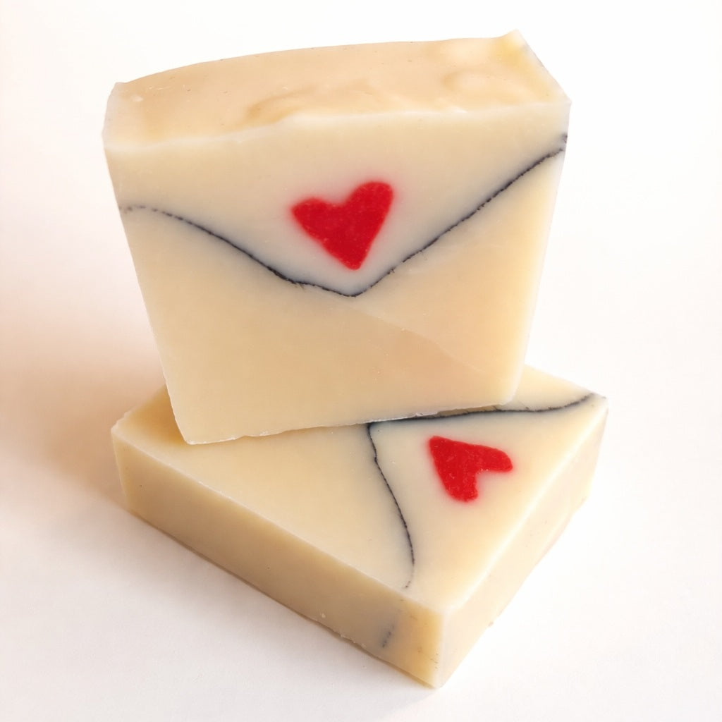 Love Letter handmade soap shaped like an envelope with a red heart, photographed on a clean white background