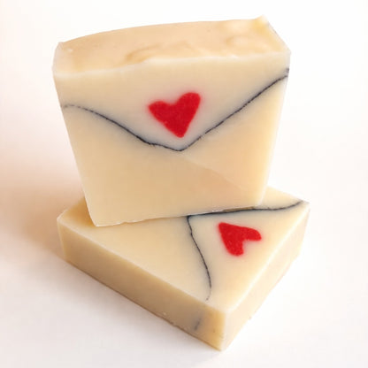 Love Letter handmade soap shaped like an envelope with a red heart, photographed on a clean white background
