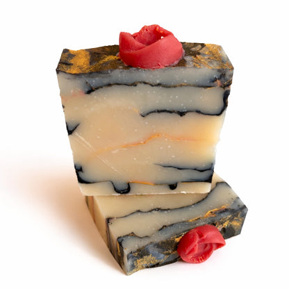 marbled looking handmade soap with rose on top photographed on white backround