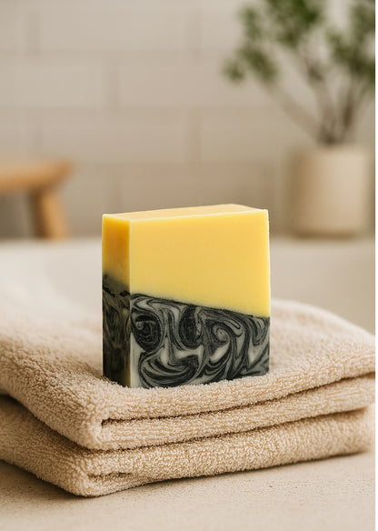 handmade lemon and charcoal swirl soap on a folded towel