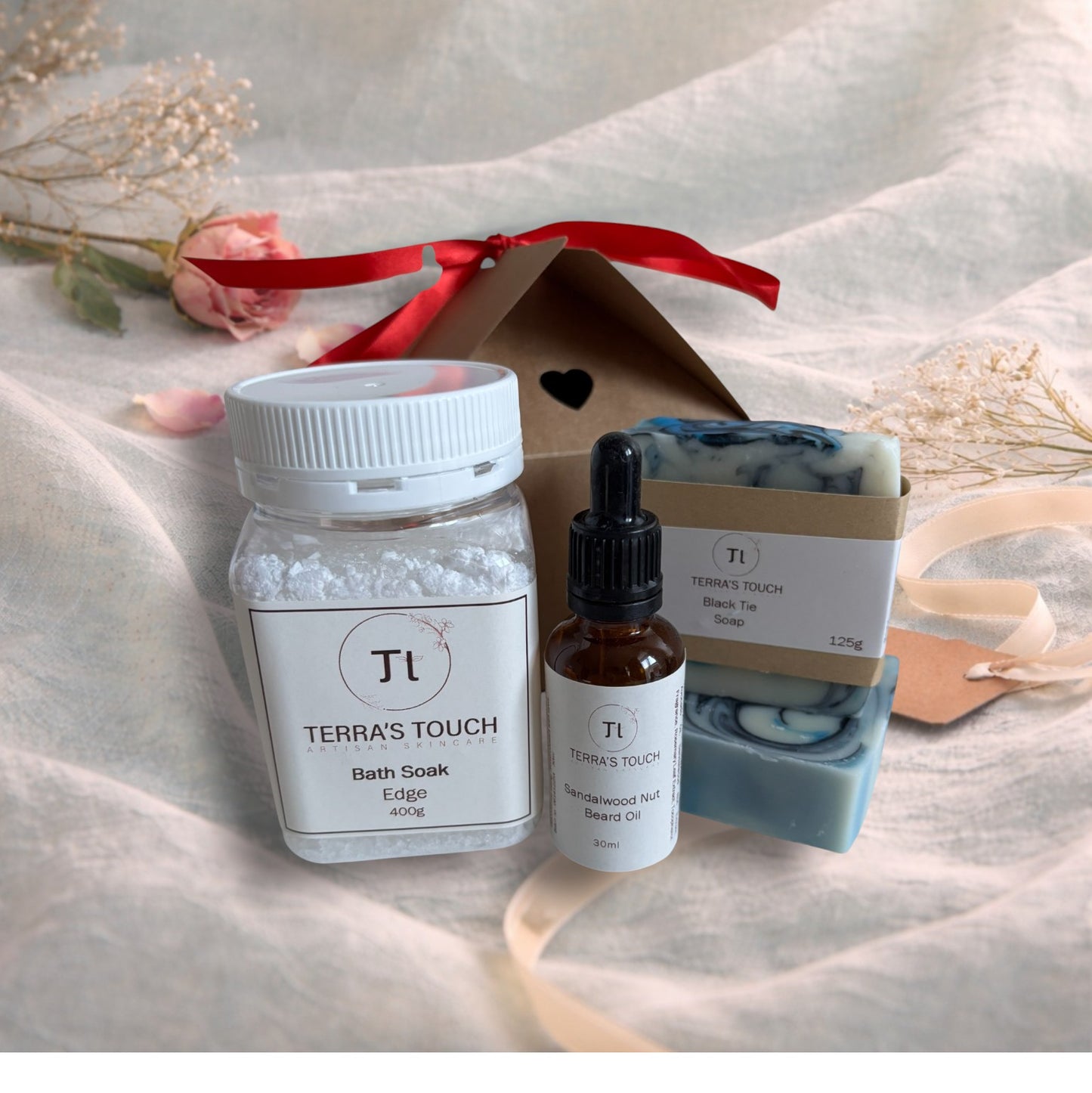 bath soak, face or beard oil and handmade soap on a valentine background with aqua linen, pink rose and craft gift box