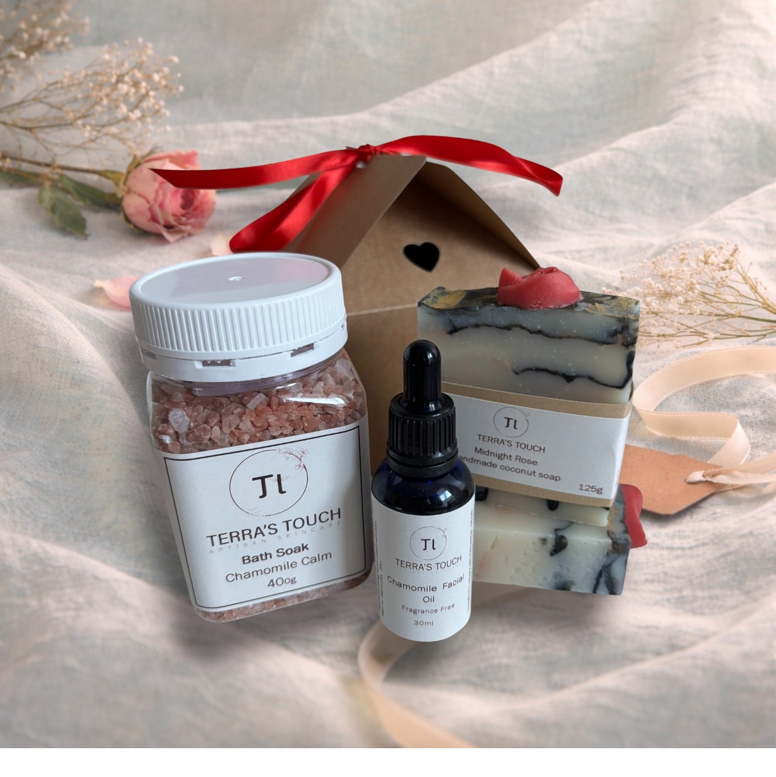 bath soak, face or beard oil and handmade soap on a valentine background with aqua linen, pink rose and craft gift box
